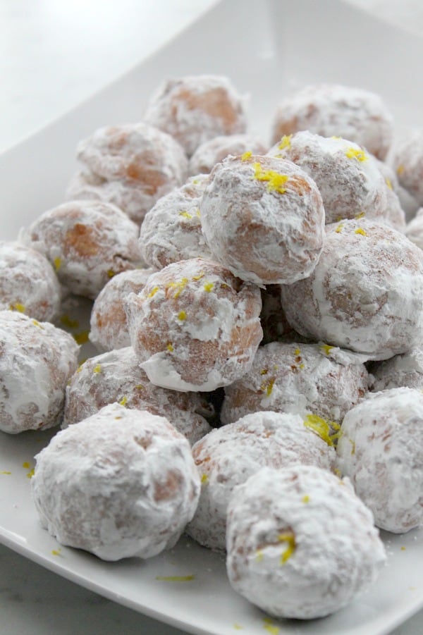 The best way to ring in Spring with with lots of citrus recipes including these Lemon Donut Holes! Lemon Donut Holes on white plate