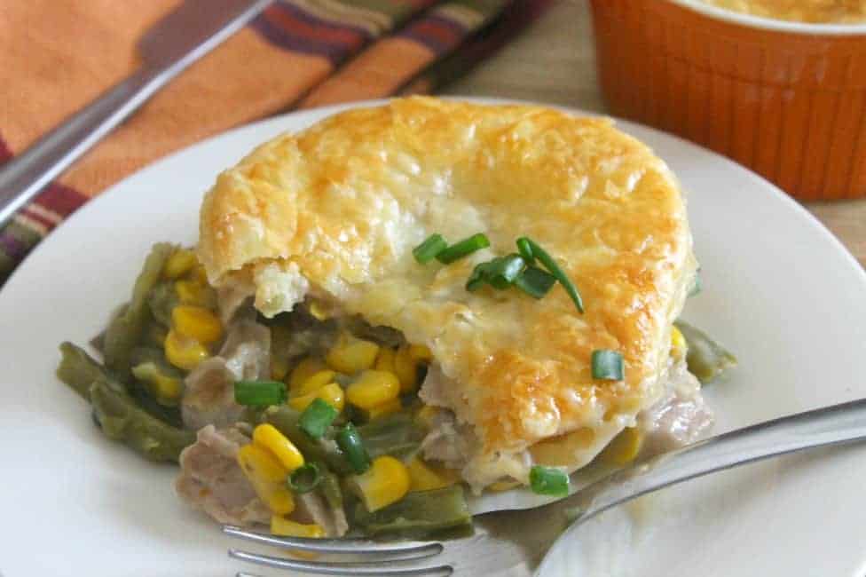 Leftover Turkey Puff Pastry Pot Pies is perfect for Thanksgiving leftovers. With turkey, green beans, corn, and other vegetables can be used! Leftover Turkey Puff Pastry Pot Pies on white plate with fork.