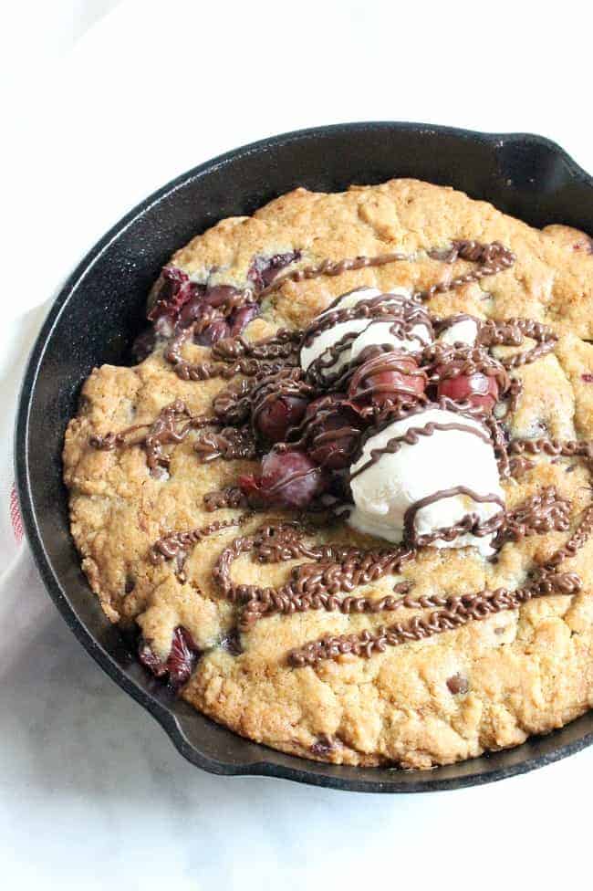 Warm chocolate chip cookie and cherries makes this delicious gooey Chocolate Cherry Skillet Cookie the perfect dessert for two! | The Bitter Side of Sweet #cookie #cherry #chocolate #dessert Chocolate Cherry Skillet Cookie in skillet
