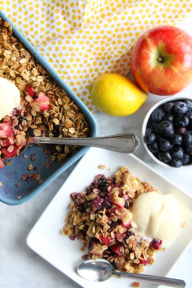 This Apple Blueberry Crisp is made with just a few ingredients of fresh fruit, honey and oats! You will love this lightened up dessert! Apple Blueberry Crisp on white plate