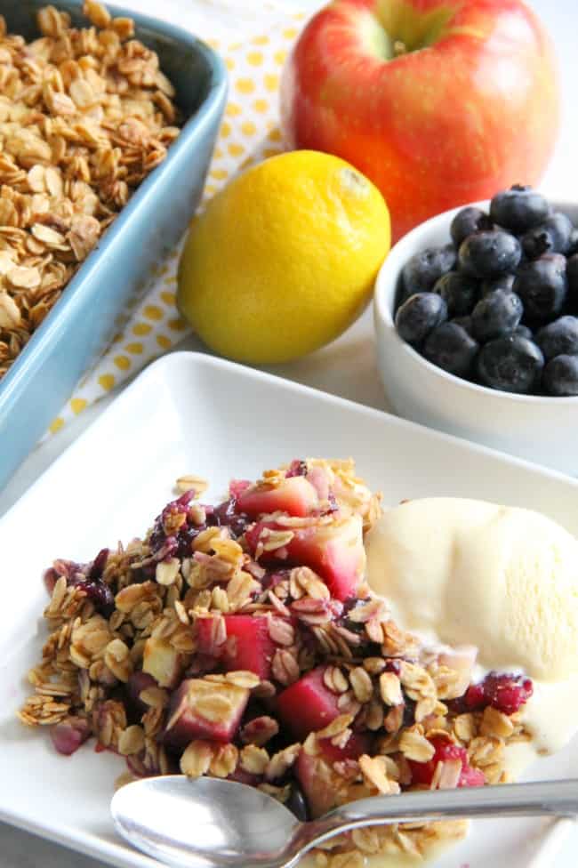 This Apple Blueberry Crisp is made with just a few ingredients of fresh fruit, honey and oats! You will love this lightened up dessert! Apple Blueberry Crisp on white plate