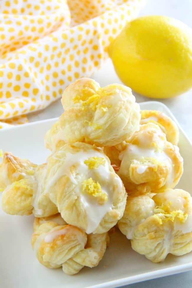 These Puff Pastry Lemon Knots are super easy to make but full of lemon citrus flavor! Perfect to make for a simple dessert! Puff Pastry Lemon Knots on white plate