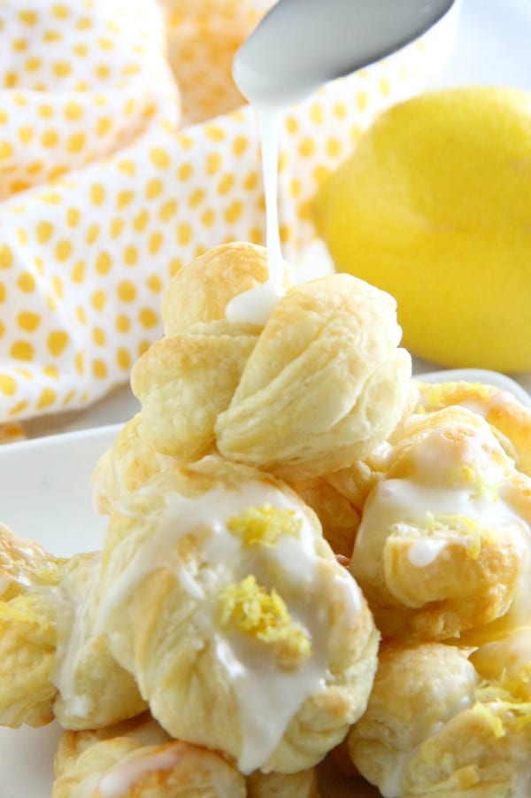 These Puff Pastry Lemon Knots are super easy to make but full of lemon citrus flavor! Perfect to make for a simple dessert! Puff Pastry Lemon Knots on white plate