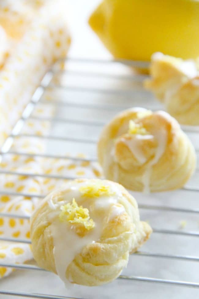 These Puff Pastry Lemon Knots are super easy to make but full of lemon citrus flavor! Perfect to make for a simple dessert! Puff Pastry Lemon Knots on white plate