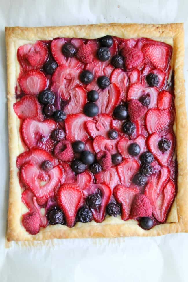 This easy Mixed Berry Tart makes for one spectacular summer dessert. It couldn’t be easier and easily adapted to any berry you wanted to use! Mixed Berry Tart on parchment paper