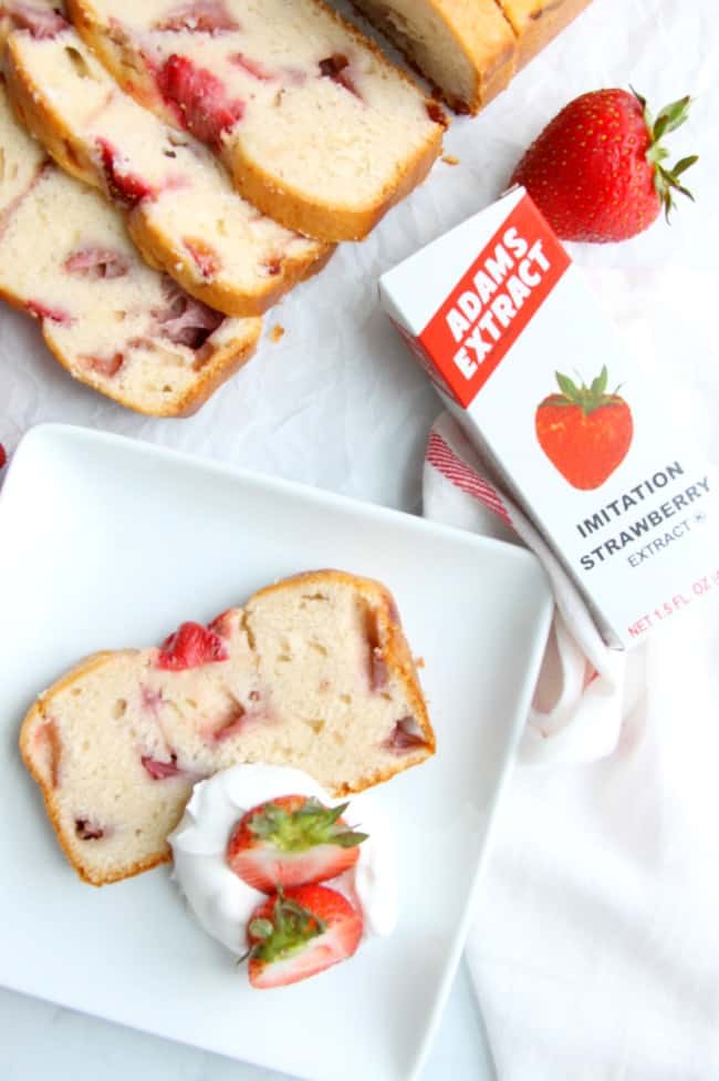 Take a classic pound cake and add summer strawberries to it to make a delicious moist cake! This Strawberry Sour Cream Pound cake will not disappoint! | The Bitter Side of Sweet Strawberry Sour Cream Pound Cake on a white plate