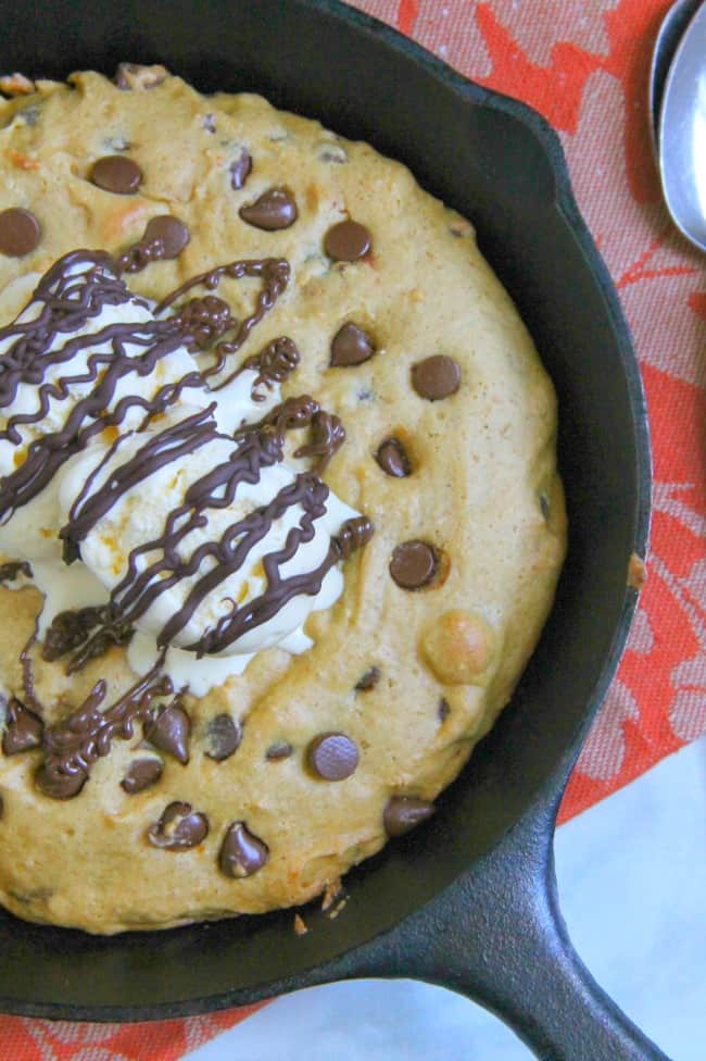 This Chocolate Chip Pumpkin Skillet Cookie is so much easier to make then a batch of cookies! It's super easy to make and perfect for fall! Chocolate Chip Pumpkin Skillet Cookie close up topped with ice cream and chocolate drizzle