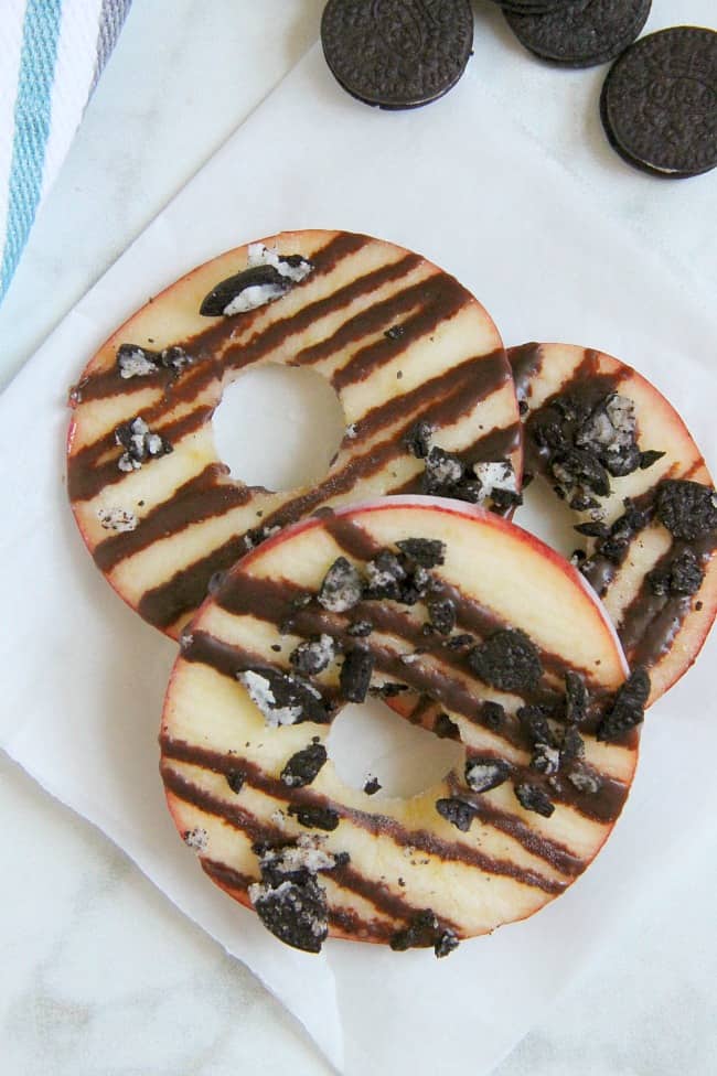 Indulging in this back to school treat for kids by adding fruit and dark chocolate to these Chocolate Oreo Apple Donuts! Your kids will be jumping for joy! | The Bitter Side of Sweet #SnackTimeDelight #ad #oreo #chocolate #apples Chocolate Oreo Apple Donuts white background