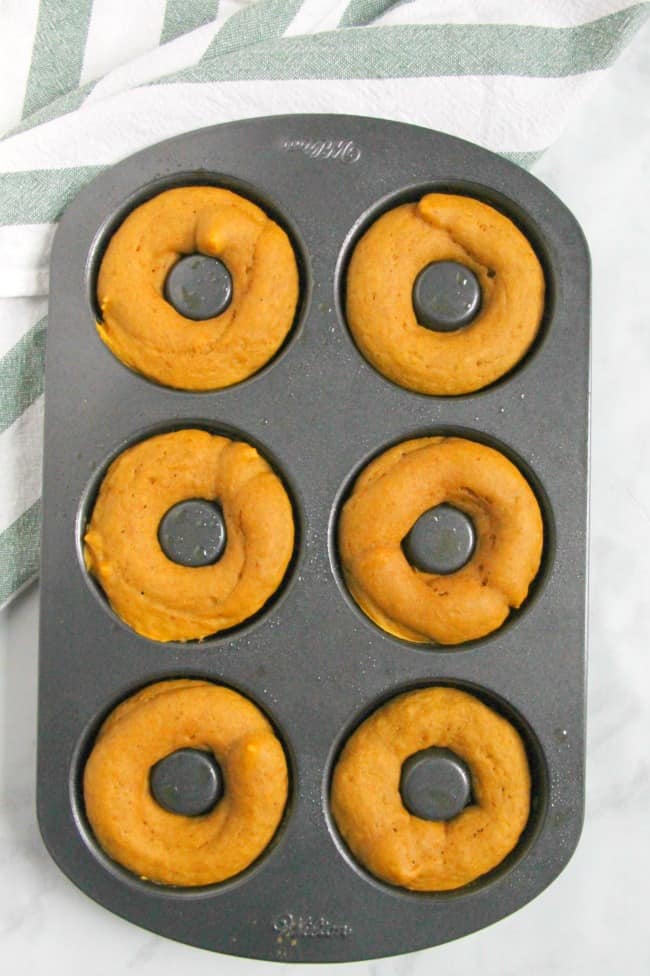 These Pumpkin Chocolate Donuts will not disappoint. They are a soft baked donut that has chocolate throughout. This makes the perfect fall treat! | The Bitter Side of Sweet #pumpkinweek #sponsored #pumpkin #donuts #breakfast Pumpkin Chocolate Donuts