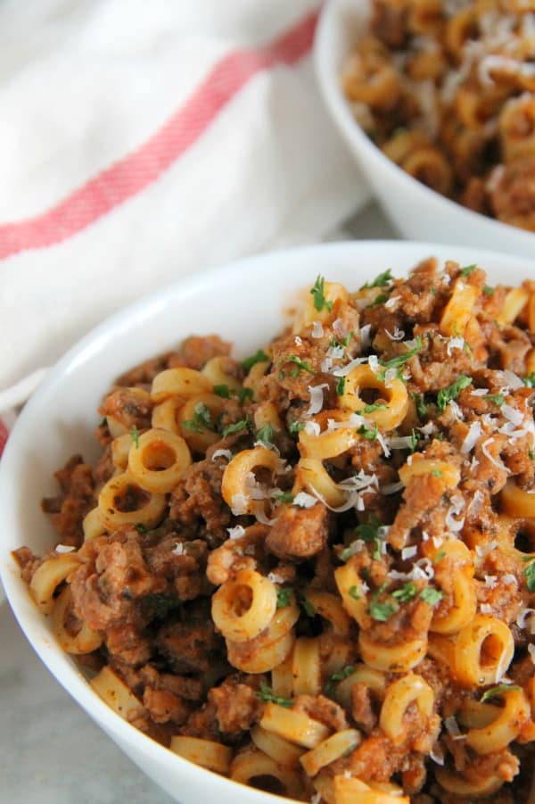 Easy Homemade Spaghetti O's are a family favorite! Made with tomato sauce, spices and ground beef. Fun large ring pasta noodles completes this meal! | The Bitter Side of Sweet #farmtocan #pasta #groundbeef #30minutemeals Homemade Spaghetti O's in white bowl