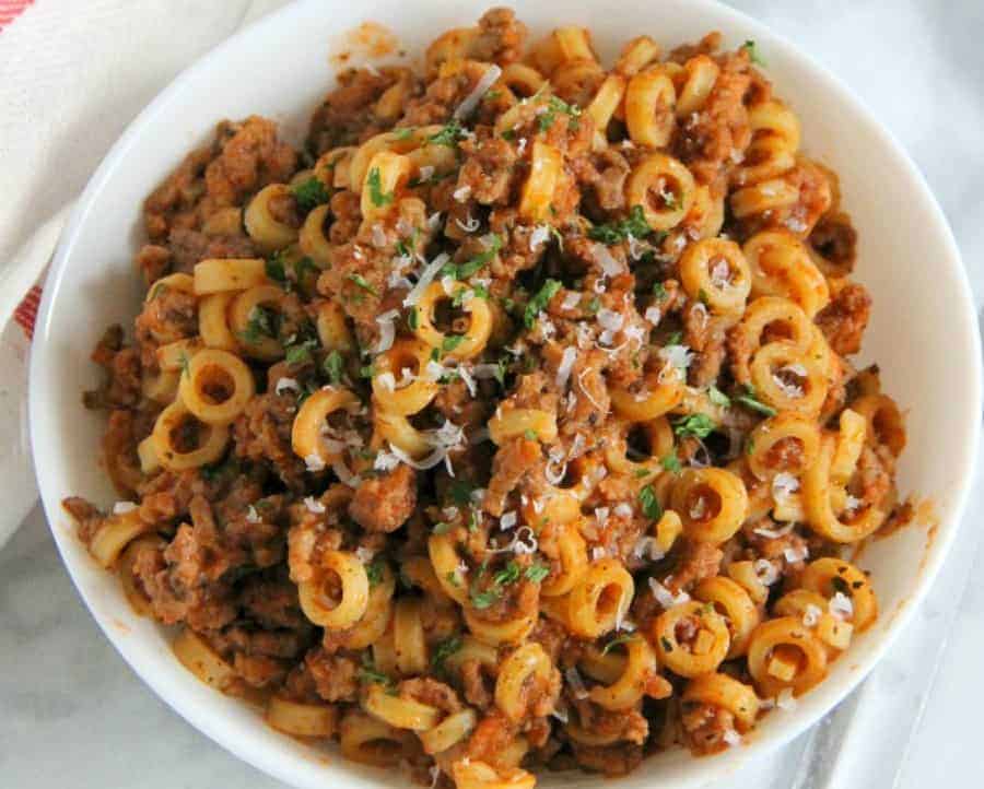 Easy Homemade Spaghetti O's are a family favorite! Made with tomato sauce, spices and ground beef. Fun large ring pasta noodles completes this meal! | The Bitter Side of Sweet #farmtocan #pasta #groundbeef #30minutemeals Homemade Spaghetti O's in white bowl