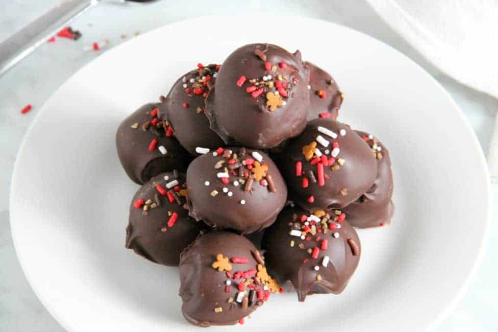 These Cookie Butter Balls are a twist on the classic candy, peanut butter balls! You will love the creamy texture of the cookie butter covered in semi sweet chocolate! Cookie Butter Balls on white plate