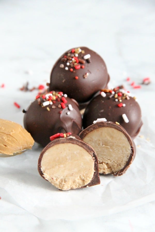These Cookie Butter Balls are a twist on the classic candy, peanut butter balls! You will love the creamy texture of the cookie butter covered in semi sweet chocolate! | The Bitter Side of Sweet #christmassweetsweek #ad #chocolate #candy Cookie Butter Balls on white plate