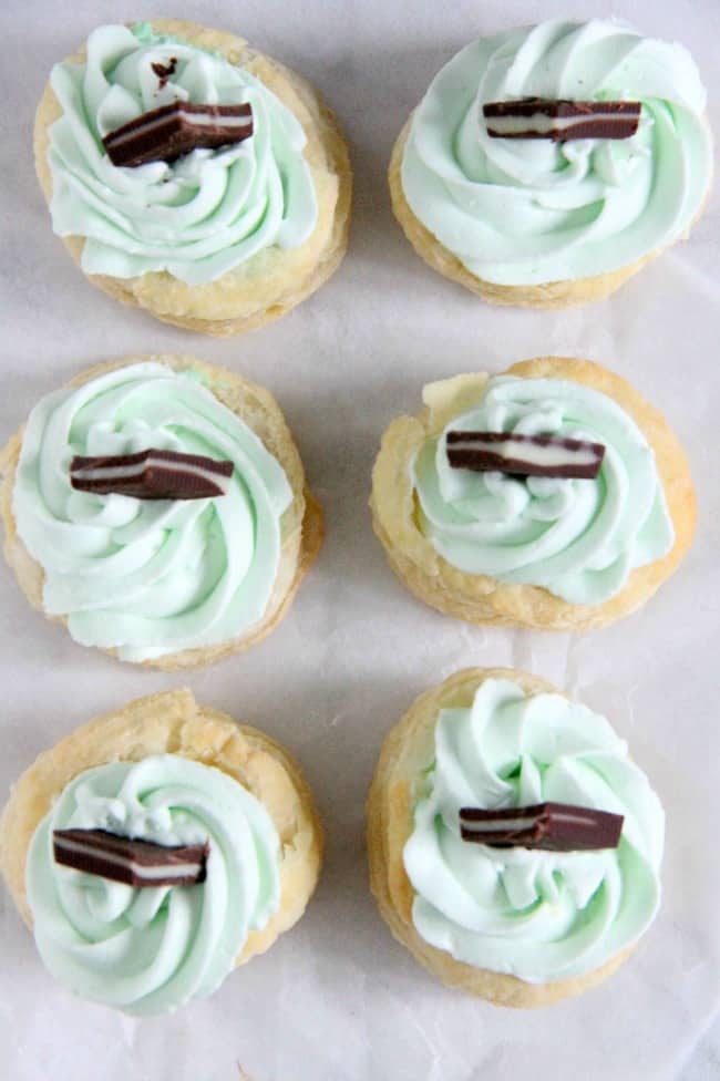 Mint Chocolate Puff Pastry Tartlets are the perfect individual dessert for entertaining! The flavors of mint and chocolate pair well with a whipped cream frosting, to make this out of this world! Mint Chocolate Puff Pastry Tartlets on white background