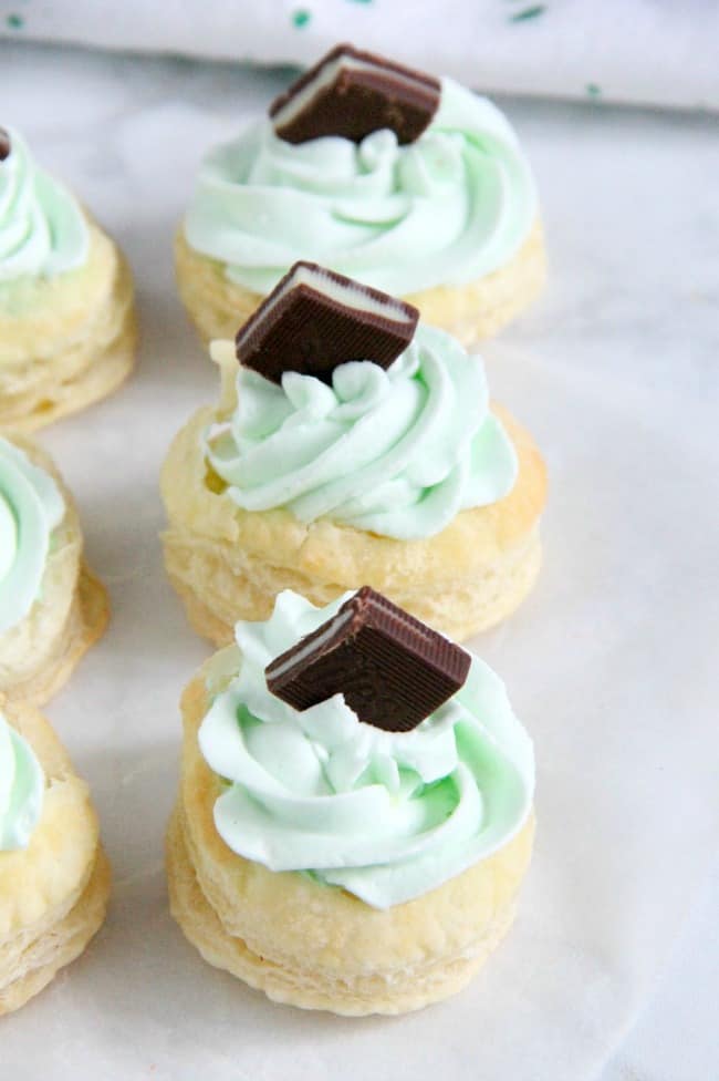 Mint Chocolate Puff Pastry Tartlets are the perfect individual dessert for entertaining! The flavors of mint and chocolate pair well with a whipped cream frosting, to make this out of this world! Mint Chocolate Puff Pastry Tartlets on white background