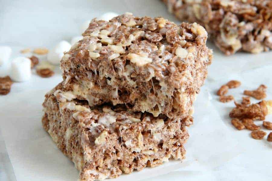 Cocoa Marshmallow Treats are a fun twist to traditional cereal treats! I've added in some chocolate cereal to take these to the next level! Cocoa Marshmallow Treats on white paper