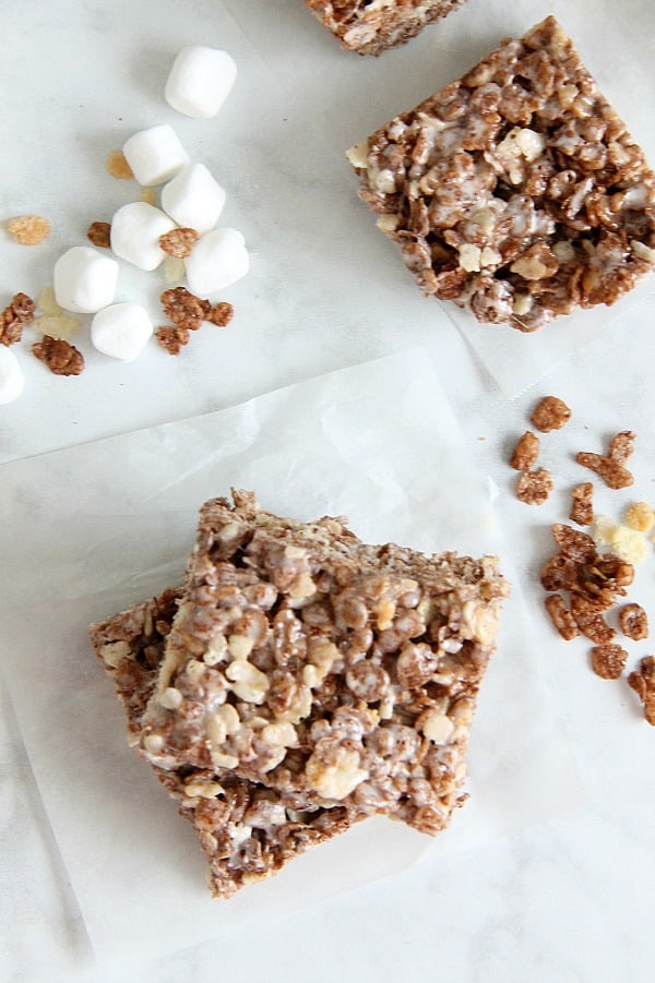 Cocoa Marshmallow Treats are a fun twist to traditional cereal treats! I've added in some chocolate cereal to take these to the next level! Cocoa Marshmallow Treats on white paper