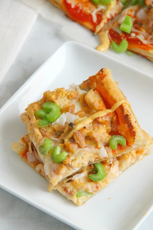 Puff Pastry Honey Mustard Chicken Pizza is made easy with the help of a rotisserie chicken and a little honey mustard sauce. Dinner is done, y'all! Puff Pastry Honey Mustard Chicken Pizza on white plate