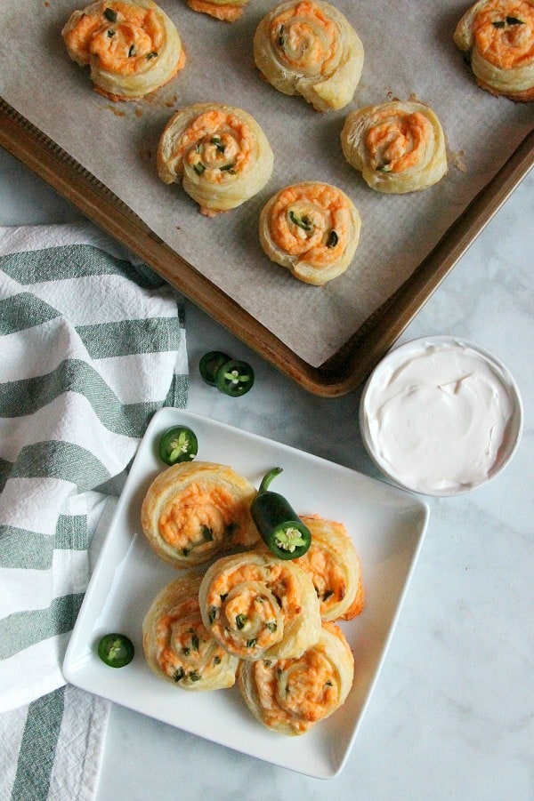 Puff Pastry Jalapeño Popper Pinwheels are just as ready for a game day as you are! They transport perfectly for tailgates. Puff Pastry Jalapeno Popper Pinwheels on white plate