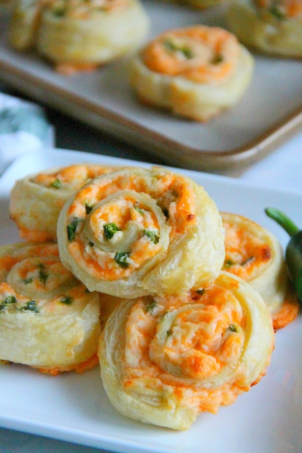 Puff Pastry Jalapeño Popper Pinwheels are just as ready for a game day as you are! They transport perfectly for tailgates. Puff Pastry Jalapeno Popper Pinwheels on white plate