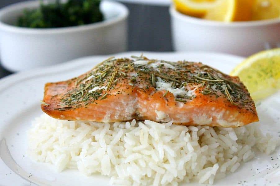 Baked Herbed Salmon perfect for fish Fridays or all year round! Easy salmon topped with a few herbs and baked to make a simple easy dinner. Baked Herbed Salmon on white plate