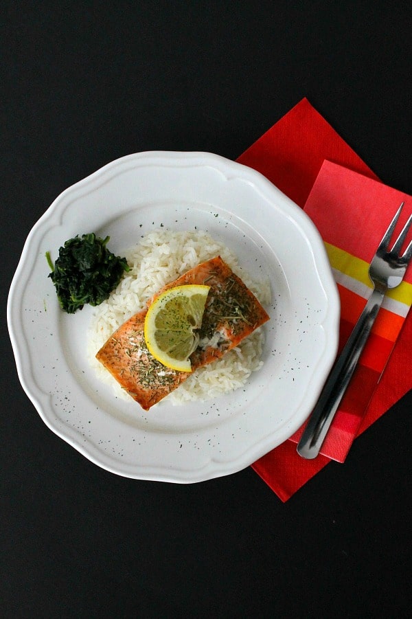 Baked Herbed Salmon perfect for fish Fridays or all year round! Easy salmon topped with a few herbs and baked to make a simple easy dinner. Baked Herbed Salmon on white plate