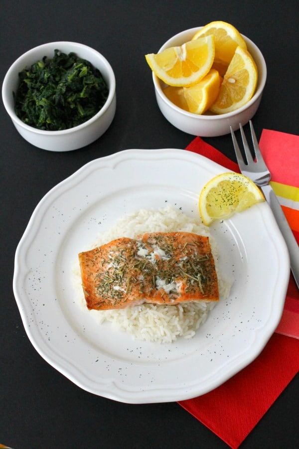Baked Herbed Salmon perfect for fish Fridays or all year round! Easy salmon topped with a few herbs and baked to make a simple easy dinner. Baked Herbed Salmon on white plate