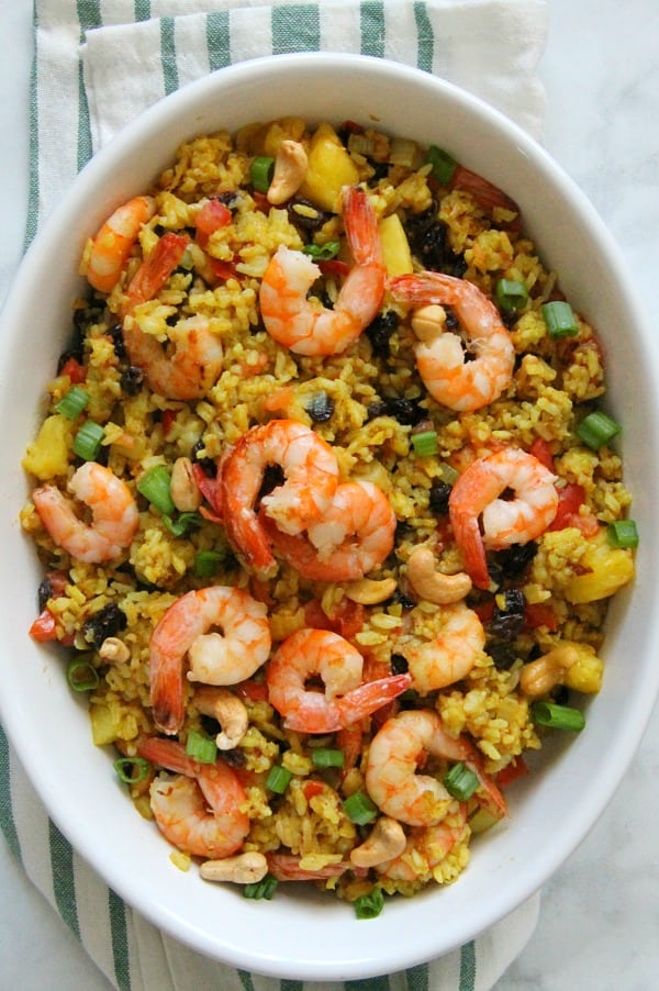This Pineapple Fried Rice is the best combination of sweet and savory! Seasoned with curry and fruit this fried rice will not disappoint! Pineapple Fried Rice in white bowl