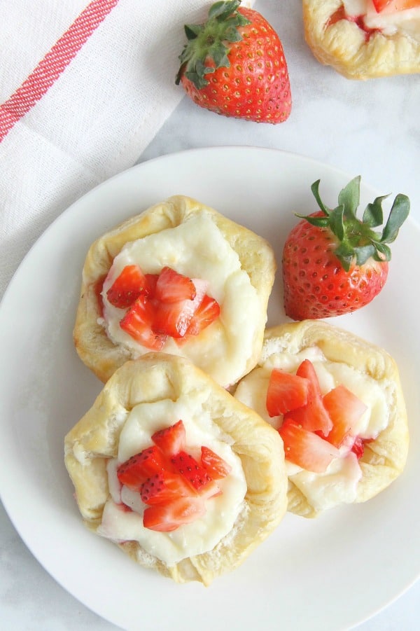 Making Strawberry Cream Cheese Danishes should probably be on your weekend agenda stat. They're so easy, and completely irresistible. Strawberry Cream Cheese Danish on white plate
