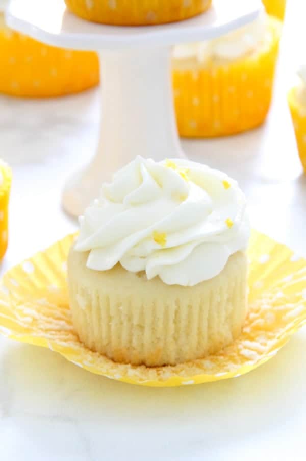 Moist and delicious Homemade Lemon Cupcakes topped with a homemade cream cheese frosting with added lemon zest. Perfect for any day of the week! | The Bitter Side of Sweet Lemon Cupcakes on white background
