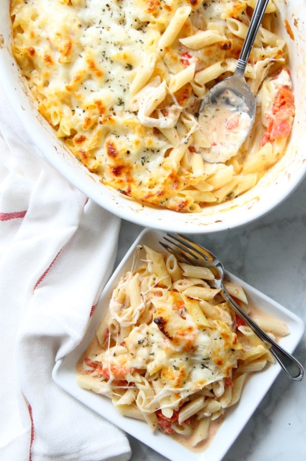 This Cheesy Tomato Pasta Bake is an irresistible casserole the whole family will nosh! It's vegetarian-friendly, and oh so good. Look at that bubbly cheese. Cheesy Tomato Pasta Bake on white plate