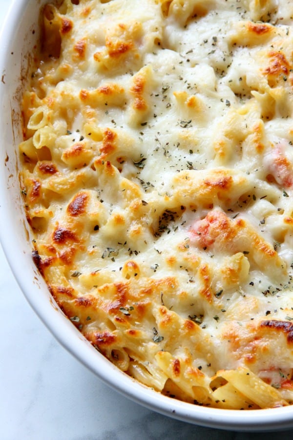 This Cheesy Tomato Pasta Bake is an irresistible casserole the whole family will nosh! It's vegetarian-friendly, and oh so good. Look at that bubbly cheese. Cheesy Tomato Pasta Bake in white bowl