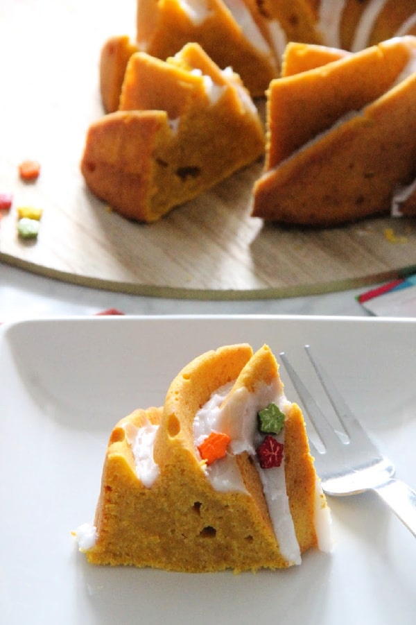 Moist and delicious Easy Pumpkin Bundt Cake is a must to make this fall season! Spiced with a little cinnamon and a lot of pumpkin this cake is simple! Easy Pumpkin Bundt Cake on white plate