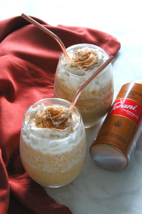 With just a few ingredients you can make your own coffee shop favorite drink! This Easy Pumpkin Frappuccino has all of the flavors of fall! Easy Pumpkin Frappuccino in glass