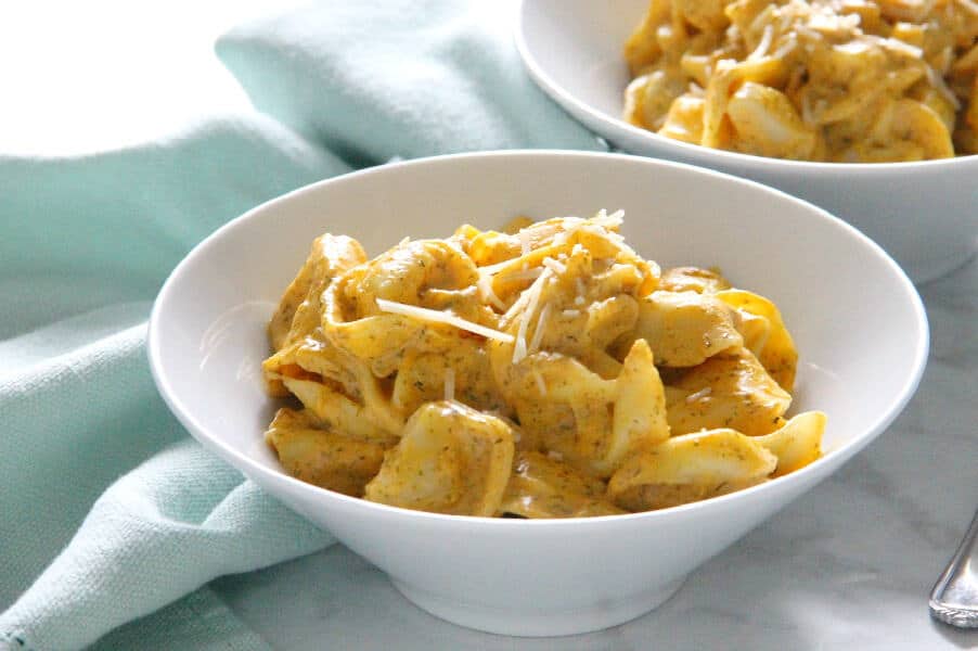 Creamy Pumpkin Tortellini is the simple supper your fall menu needs. This light, creamy sauce has just the right flavor profile to match up to pumpkin! Creamy Pumpkin Tortellini in white bowl