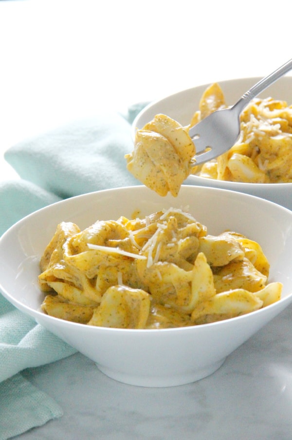 Creamy Pumpkin Tortellini is the simple supper your fall menu needs. This light, creamy sauce has just the right flavor profile to match up to pumpkin! Creamy Pumpkin Tortellini in white bowl