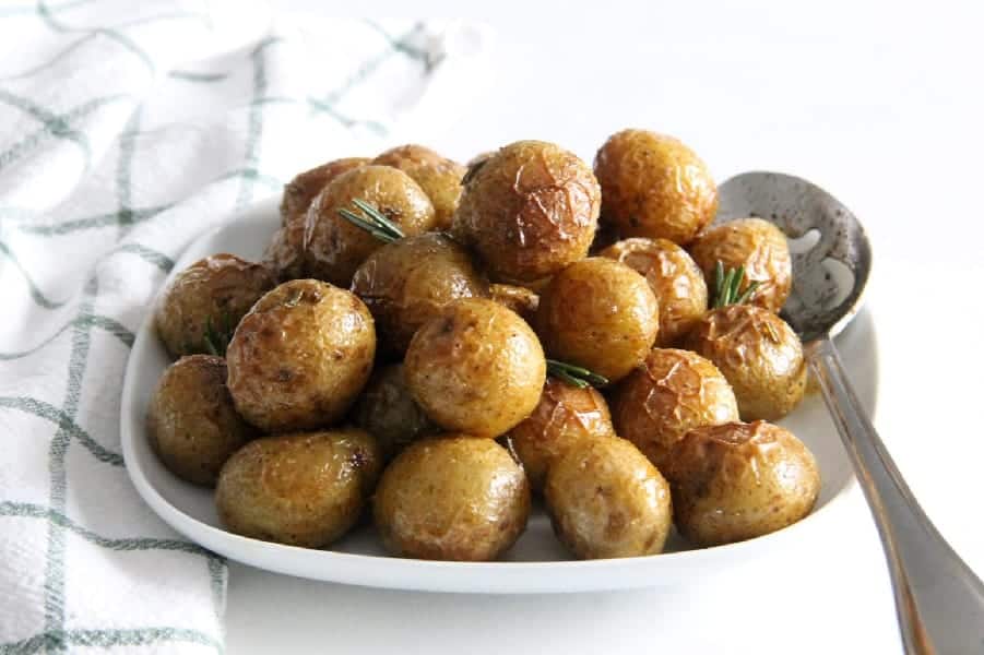 Spicy Roasted Rosemary Potatoes bakes up quick and easy! Creamy potatoes makes for a sensational side dish with a little kick to them! Spicy Roasted Rosemary Potatoes on white plate