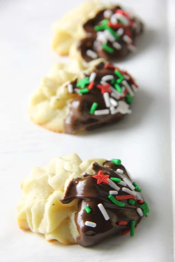 Italian Butter Cookies are just like what you would find in Italian bakeries! Dipped in chocolate and sprinkles, they're a spectacular treat. Italian Butter Cookies on white background