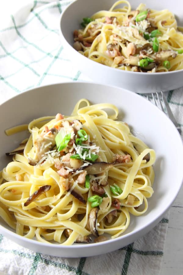 This Pancetta Mushroom Fettuccine can make an easy weeknight dinner, or a date night dinner. It comes together quickly, but feels fancy! | The Bitter Side of Sweet Pancetta and Mushroom in white bowls