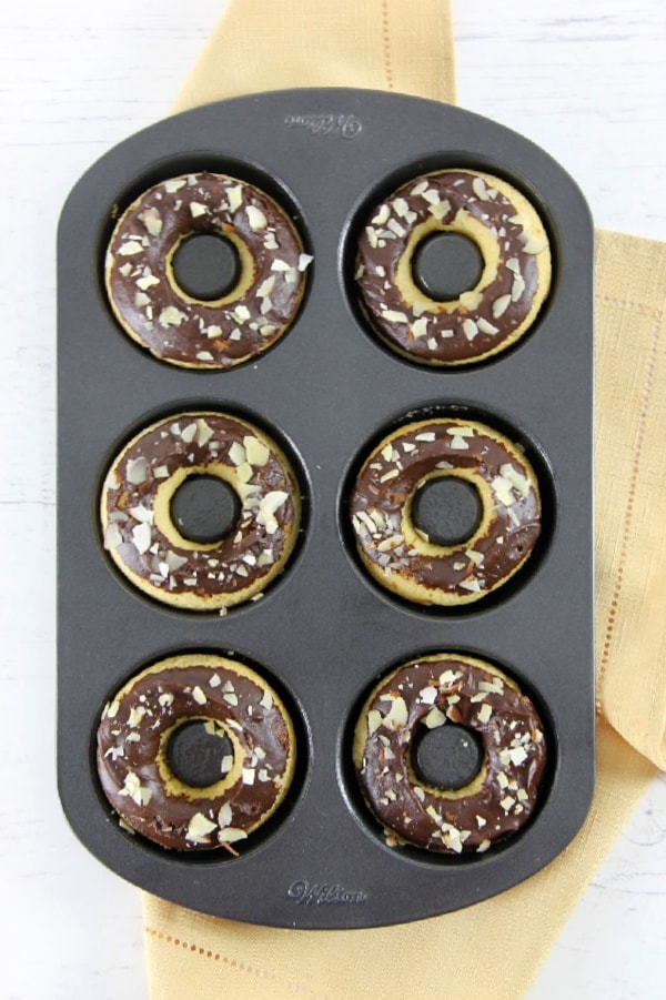 These Chocolate Glazed Almond Donuts are baked to perfect and topped with chocolate and almonds! They bake up in just about 10 minutes! | The Bitter Side of Sweet Chocolate Almond Glazed Donuts in donut pan