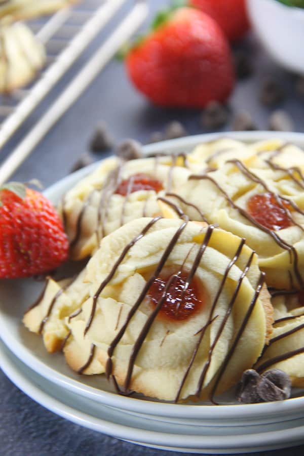 These Strawberry Chocolate Butter Cookies are a fun twist to the classic Italian Butter Cookie! So delicious with strawberry jam and chocolate drizzle! Strawberry Chocolate Butter Cookies on white plates