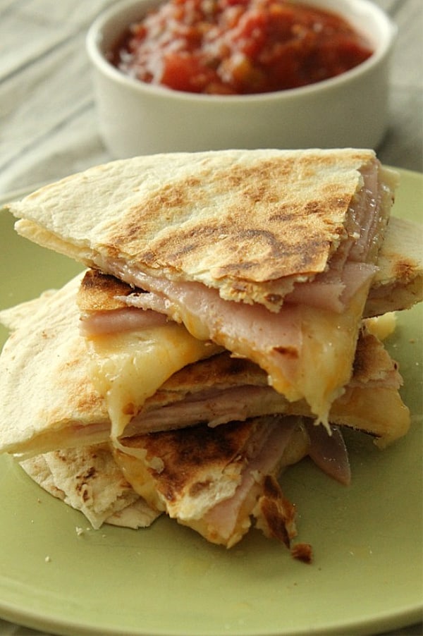 Easy Ham and Cheese Quesadillas made with 3 ingredients and perfect for a quick lunch or snack! Flour tortillas topped with deli ham and Mexican cheese! Ham and Cheese Quesadillas on stacked on green plate