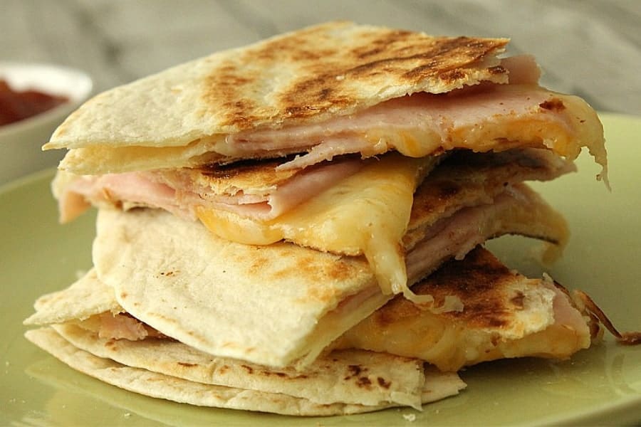 Easy Ham and Cheese Quesadillas made with 3 ingredients and perfect for a quick lunch or snack! Flour tortillas topped with deli ham and Mexican cheese! Ham and Cheese Quesadillas stacked on green plate