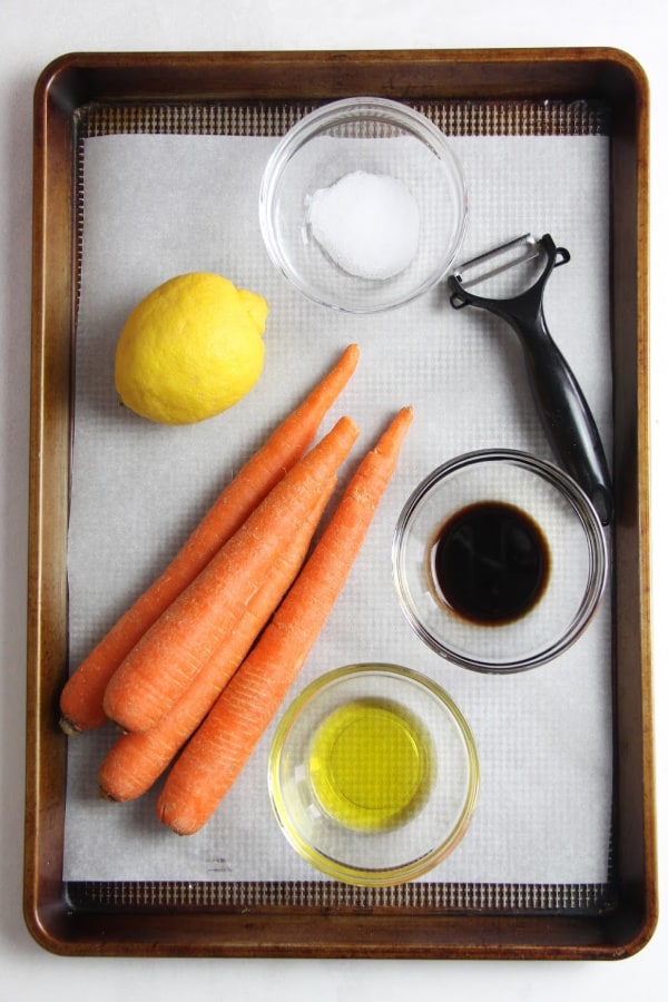 This fresh Lemon Carrot Salad is made with just 5 ingredients! With a simple dressing topped over shaved carrots this makes a simple side dish. Lemon Carrot Salad on sheet pan with ingredients