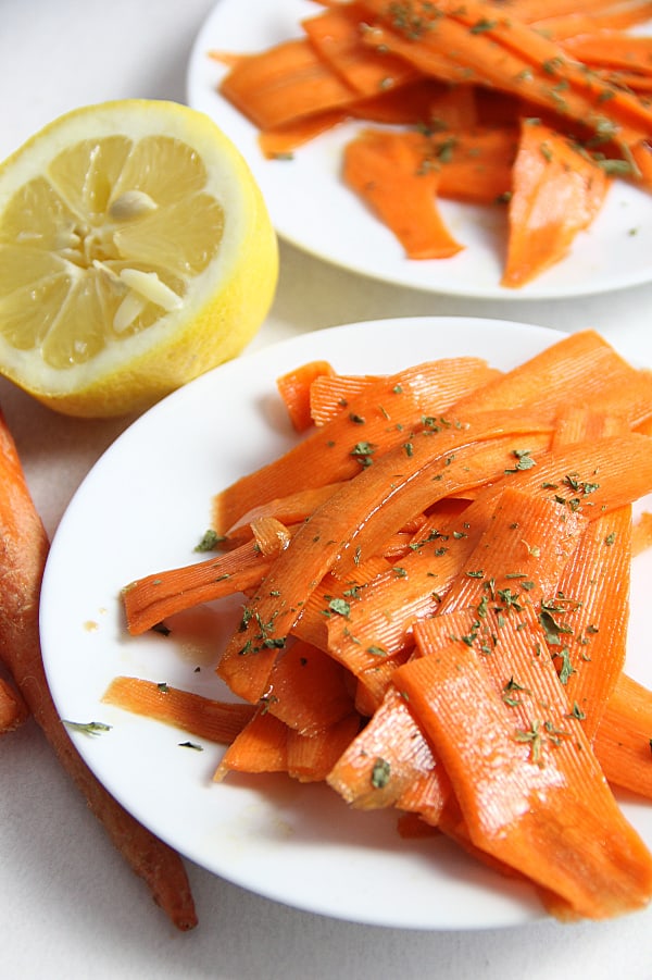 This fresh Lemon Carrot Salad is made with just 5 ingredients! With a simple dressing topped over shaved carrots this makes a simple side dish. Lemon Carrot Salad on white plate topped with parsley