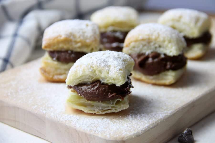 Four ingredient puff pastry dessert that brings alive these Miguelitos with Chocolate dessert! Perfect for Cinco de Mayo or any day of the week! Miguelitos with Chocolate on cutting board topped with powdered sugar