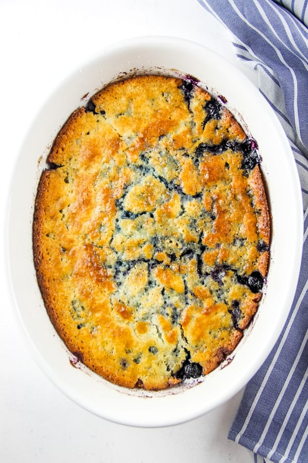 Easy Homemade Blueberry Cobbler! With an easy buttery crust mixed with fresh or frozen blueberries, this is the perfect fruit dessert! Blueberry Cobbler in white bowl