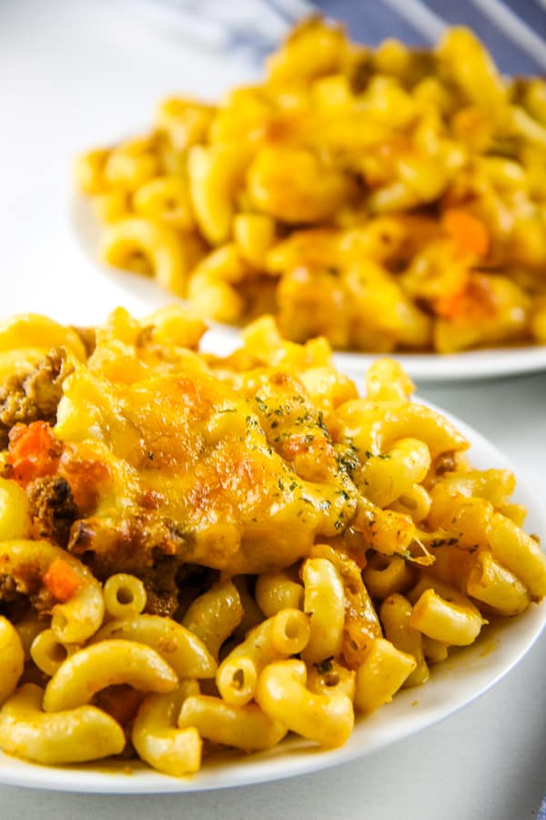 This Cheesy Macaroni Pasta Bake for a weeknight dinner! Made with my classic homemade pasta sauce, this is the perfect comfort food! Cheesy Macaroni Pasta Bake on white plate