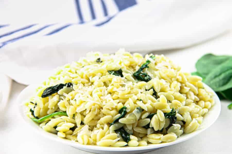 This Cheesy Spinach Orzo is an easy 20 minute meal! Made with fresh spinach, onions and garlic this tasty pasta is also loaded with freshly grated cheese!