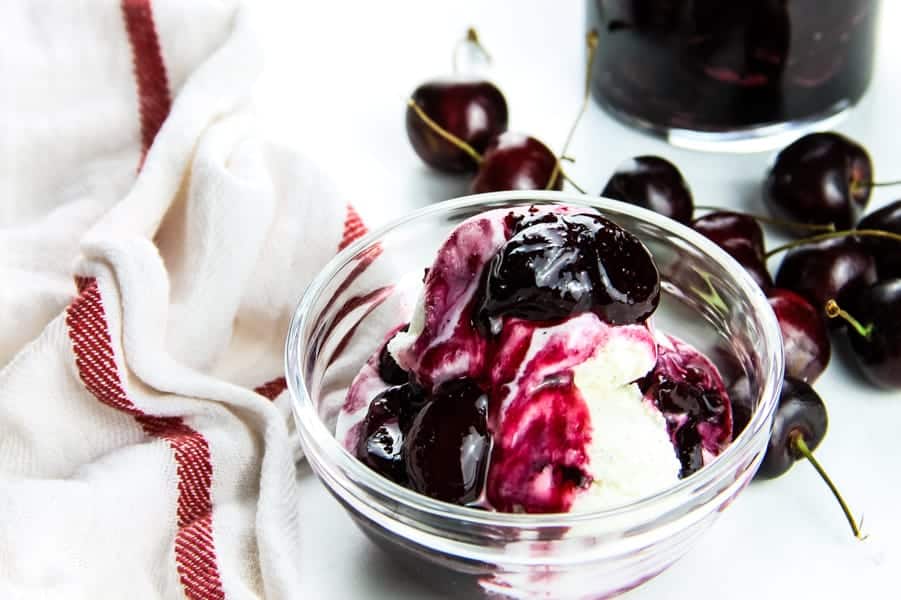 With 4 ingredients this Easy Cherry Compote is the best topping for putting on ice cream, pound cake, or even granola! Perfectly made with fresh cherries! Easy Cherry Compote on ice cream in glass bowl
